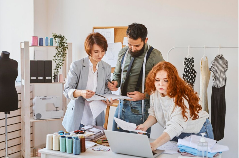 Tres profesionales de la moda trabajan en un taller analizando su facturación