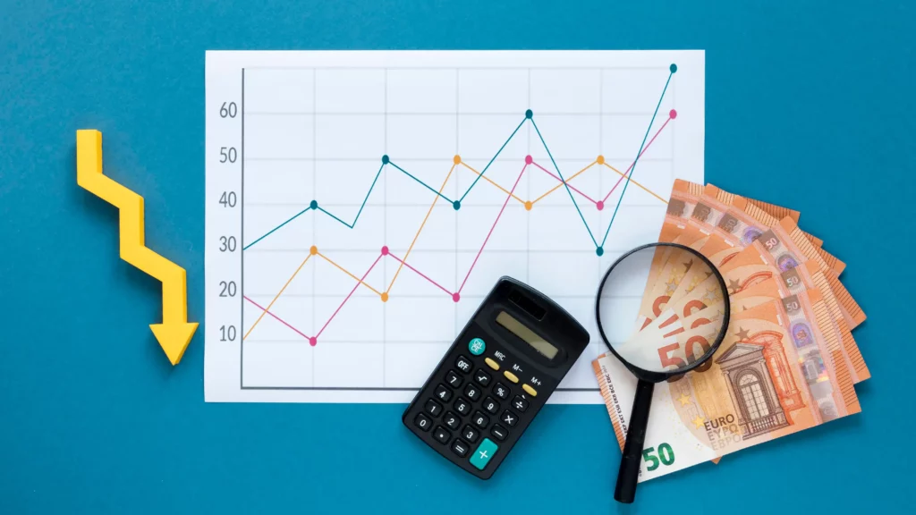 Gráfico de líneas mostrando fluctuaciones en el valor económico, con calculadora, lupa, dinero en efectivo