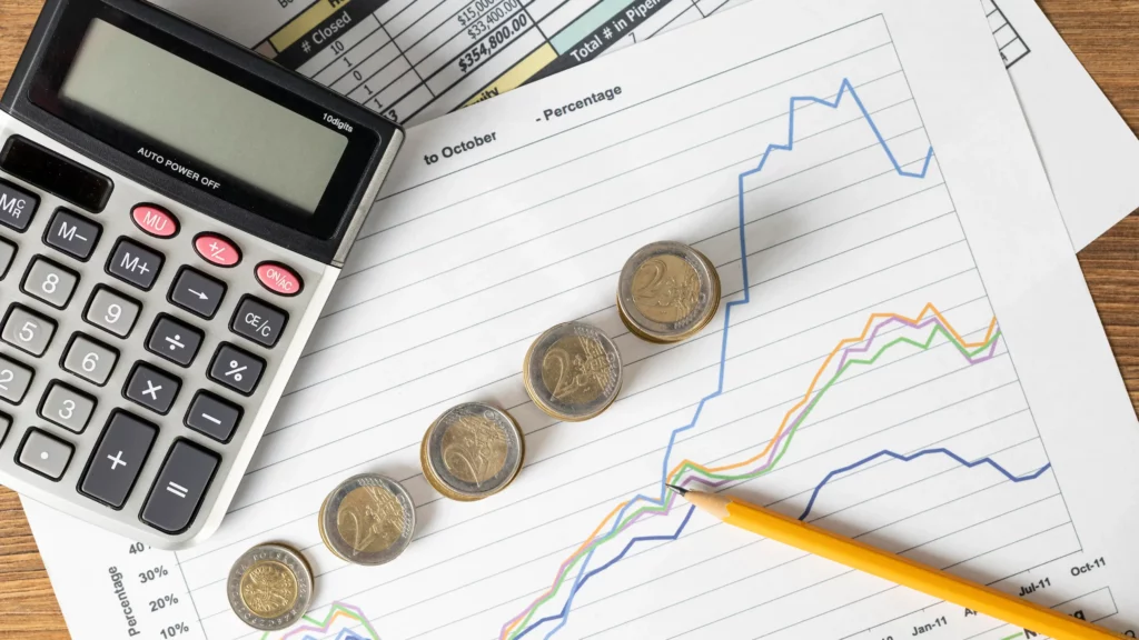 [Gráficos de crecimiento financiero, monedas y una calculadora, ilustrando la planificación fiscal y el cálculo del ajuste anual por inflación