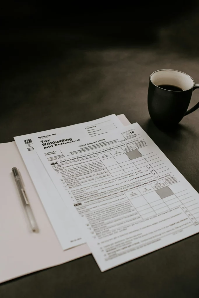 Formulario fiscal sobre estimaciones y retenciones junto a una taza de café y una pluma