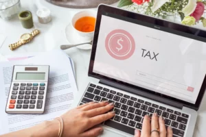 Oficina con laptop, calculadora y reportes contables usados para planear un cambio de régimen fiscal en el SAT